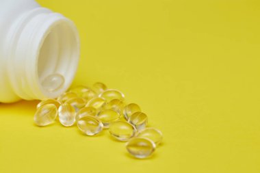 ilaç ilaç kapsülleri, hap lar ve kapsüller ve sarı bir arka plan üzerinde bir şişe. Metin için alan kopyalayın. haplarda medecine ve vitamin kavramı.