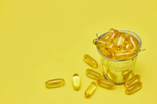 Capsule di medicina farmaceutica, pillole e capsule su uno sfondo giallo. Copia spazio per testo. Il concetto di medicina e vitamine in pillole. farmaci — Foto Stock