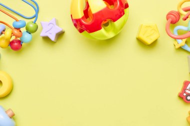 Sarı arka planda çocuk oyuncaklarının üst görüntüsü. Çocuk oyuncakları masanın üstünde. Çocuklar için reklam oyuncakları konsepti. Boşluk çocuk oyuncaklarını kopyala.