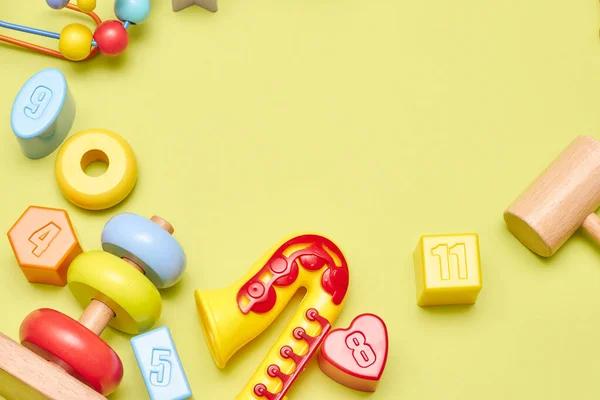 Sarı arka planda çocuk oyuncaklarının üst görüntüsü. Çocuk oyuncakları masanın üstünde. Çocuklar için reklam oyuncakları konsepti. Boşluk çocuk oyuncaklarını kopyala.