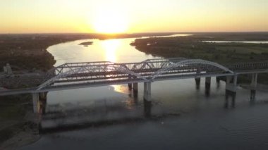 gün batımında kemerli köprü. Arabalar bir köprüde ilerliyorsunuz. kentsel trafik. Quadro video. Dron, üstten görünüm.