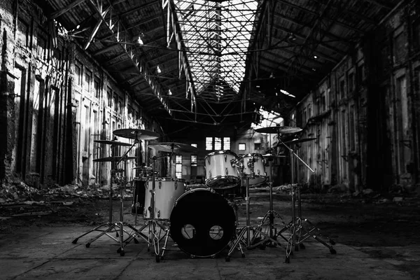 Beyaz davul seti terk edilmiş bir hangarda bir terk edilmiş kırmızı tuğla fabrikası duruyor. yıkım, sonrası kıyamet, urbex