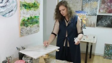 Genç ve yetenekli bir kadın sanatçı Akışkan Sanat tekniğini kullanarak bir resim çiziyor. Sıvı akrilik boyalarla resim çizmek.