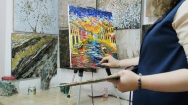 Genç yetenekli kadın ressam bir resim çiziyor. Sanatçı bir resim çizer. Sanatçı bir sanat stüdyosunda çalışıyor. Sanat galerisi.