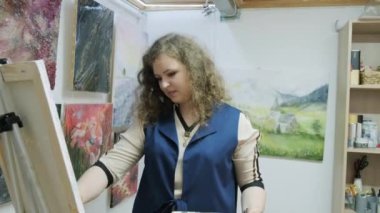 Genç yetenekli kadın ressam bir resim çiziyor. Sanatçı bir resim çizer. Sanatçı bir sanat stüdyosunda çalışıyor. Sanat galerisi.