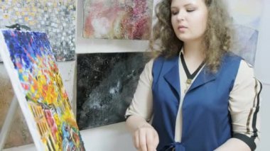 Genç yetenekli kadın ressam bir resim çiziyor. Sanatçı bir resim çizer. Sanatçı bir sanat stüdyosunda çalışıyor. Sanat galerisi.