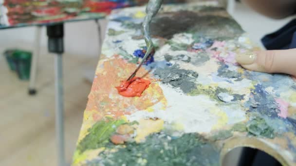年轻的有才华的女画家从一幅画的调色板上涂上颜料 画家画了一幅画 这位艺术家在一家艺术工作室工作 美术馆 — 图库视频影像