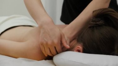 Kadın terapist omuzlarında genç bir kadına masaj yapıyor. Rahatlatıcı masaj. Terapi masajı. Alternatif tıp. Spa tedavileri.