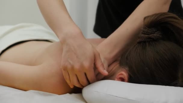 女治疗师按摩一位年轻女子的肩膀 放松按摩 治疗性按摩 替代药物 温泉治疗 — 图库视频影像