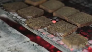 Şef, salata için kızarmış ekmek yapmak için ızgarada siyah ekmek dilimliyor.