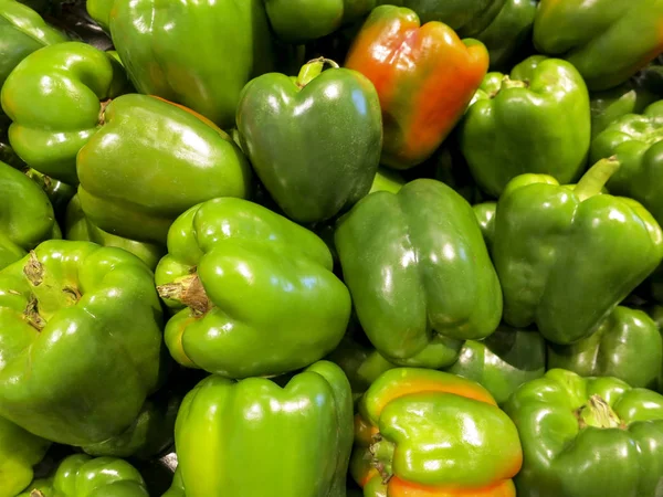 Lot of green bell peppers on a pile