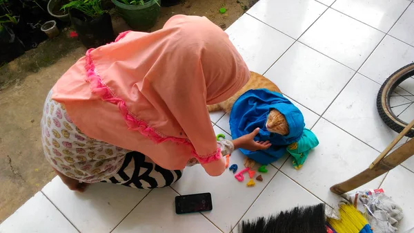 Ένα Κορίτσι Φορούν Πορτοκαλί Ijab Παίζοντας Φιλικό Γάτα Της — Φωτογραφία Αρχείου
