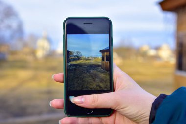 Kırsal manzara kışın soğuk bir kızın elinde telefon ekranında görüntülenir
