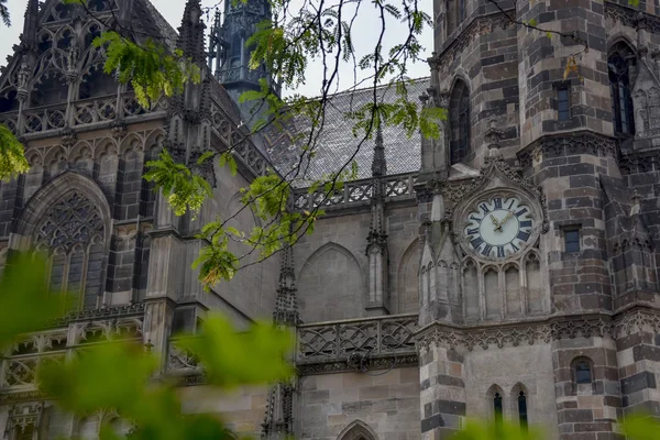 Clock on the wall of an ancient Gothic building in summer in Europe