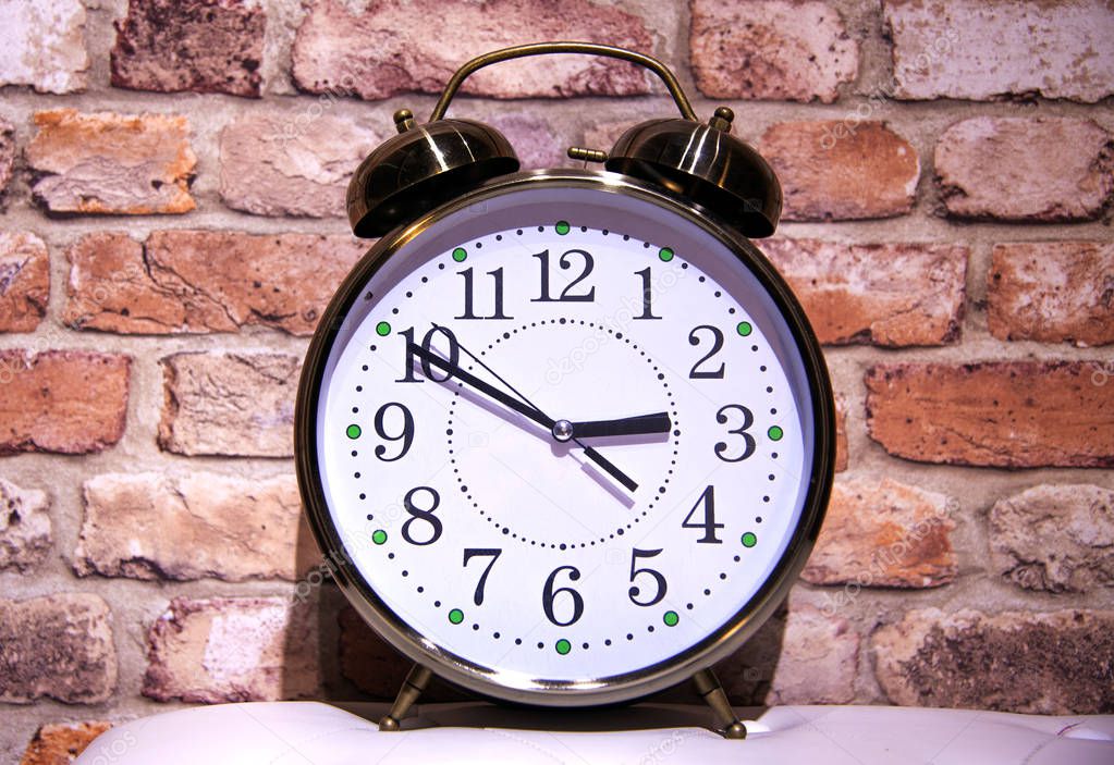 Alarm clock on brick wall background