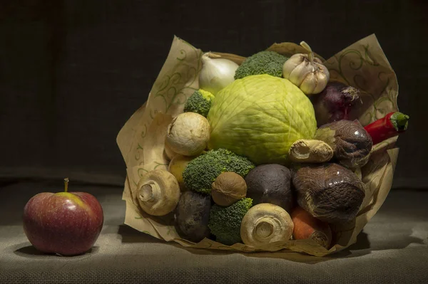 Um buquê brilhante de vegetais frescos, envolto em papel marrom, está em um pano na mesa. . — Fotografia de Stock