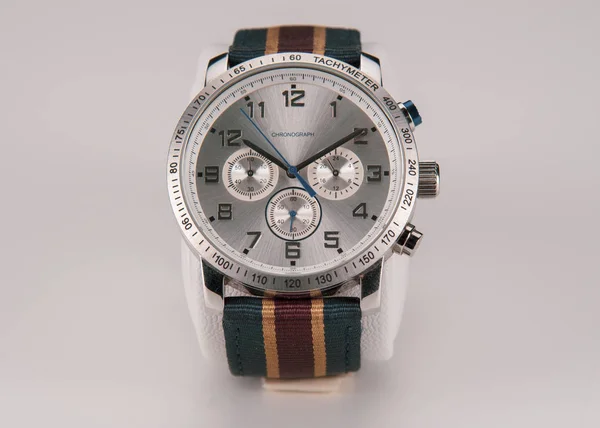 Męski zegarek na rękę ze srebrnym cyferblat kolorowy pasek na szarym tle. — Zdjęcie stockowe