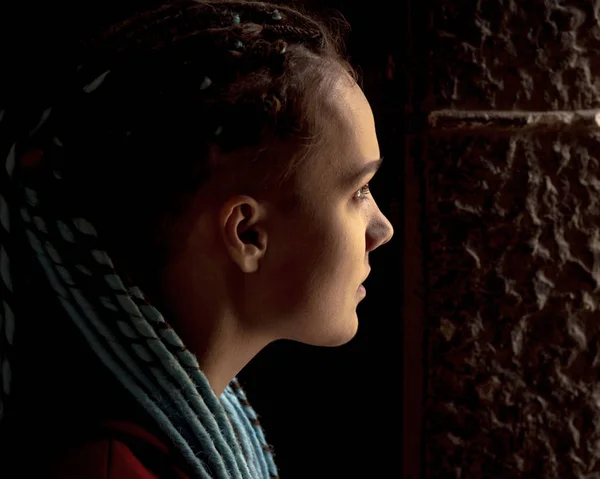 Портрет девушки с дредами в профиль с подсветкой . — стоковое фото
