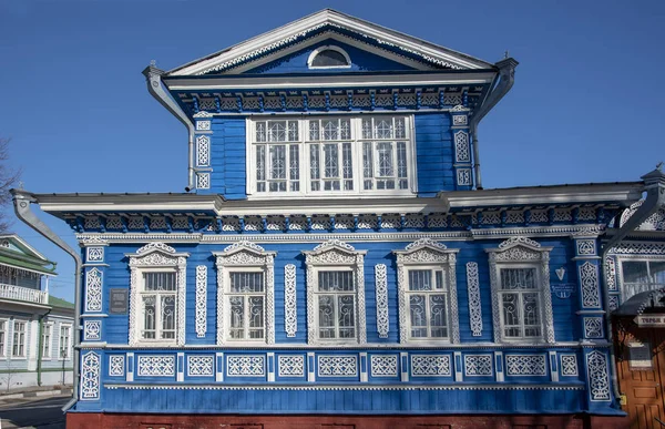Niebieska ściana domu z oknami i pięknymi rzeźbione drewniane ramy. — Zdjęcie stockowe