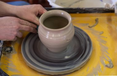 Potter 'ın tekerleği ile seramik pot yapımında Master sınıfı. Çömlek, ekseninin etrafında dönüyor.