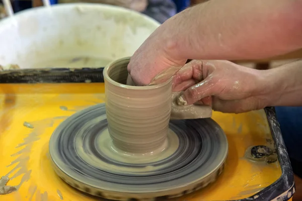 Master class on making a ceramic pot with a Potter's wheel. The pottery is rotating around its axis. — Stock Photo, Image