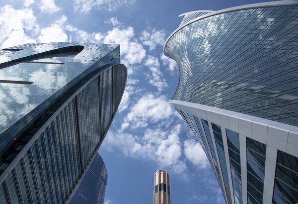 Fragments of skyscrapers against the blue sky and flying clouds.Architectural style - modernism.