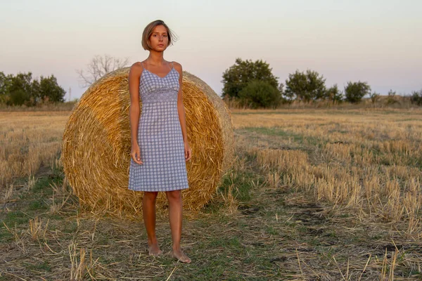 Una bella ragazza snella con un taglio di capelli corto in un abito a scacchi — Foto Stock