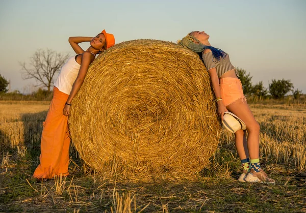 Due ragazze si aggrappano ad un pagliaio da lati diversi . — Foto Stock