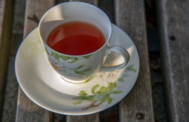 Bir fincan çay dışında ahşap bir yüzey üzerinde duruyor 