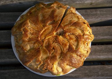 Dilimlenmiş bir Elmalı turta bir tabakta oturur 