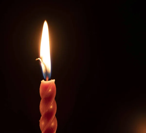 Červená zkroucená svíčka na černém pozadí. — Stock fotografie