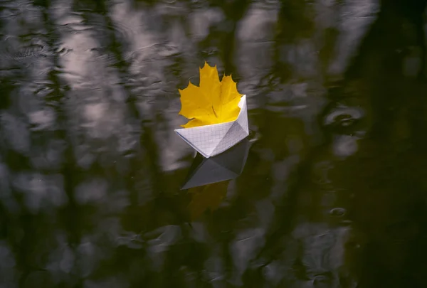 Um barco de papel flutua em uma poça — Fotografia de Stock