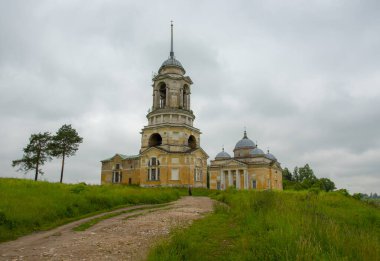 Kilise bir tepenin üzerinde duruyor, toprak bir yol ona gidiyor..