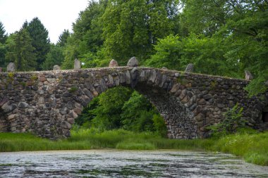 Parktaki bir göletin üzerine devasa taşlardan yapılmış bir köprü..