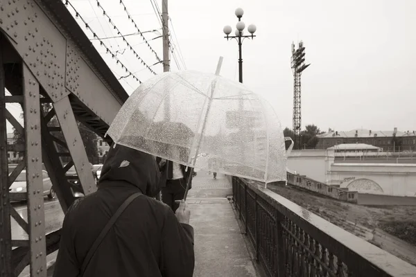 La gente camina bajo el puente con sombrillas . — Foto de Stock