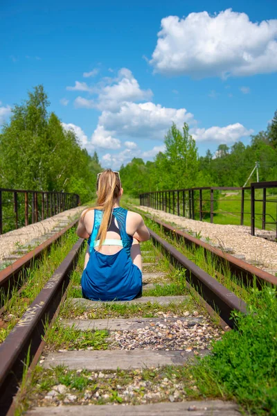 Een Blond Meisje Met Lang Haar Een Sportshirt Zit Het — Stockfoto