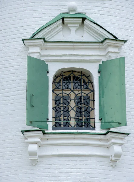 一个有漂亮拱门的有栅栏的窗户靠着一面白色的砖墙 建筑细节及元素 — 图库照片