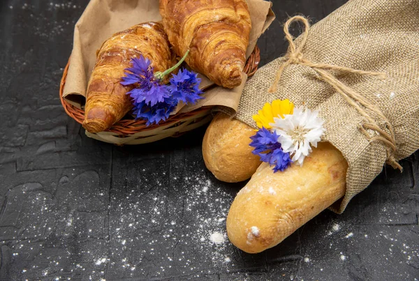 Baguettes Wrapped Coarse Linen Basket Croissants Decorated Flowers Black Slate — Stock Photo, Image