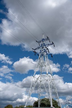 Güç hattı. Parlak mavi gökyüzüne karşı yüksek voltajlı kabloları olan bir direk..