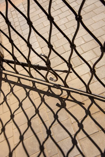 Abstract Pattern Metal Grating Its Shadow Falling Tiled Pavement — Stock Photo, Image