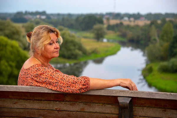 65 yaşında bir kadının portresi doğanın arka planına karşı..