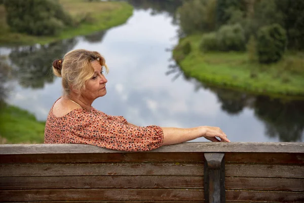 65 yaşında bir kadının portresi doğanın arka planına karşı..