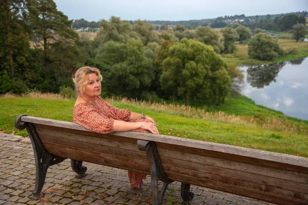 65 yaşında bir kadının portresi doğanın arka planına karşı..