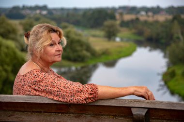 65 yaşında bir kadının portresi doğanın arka planına karşı..