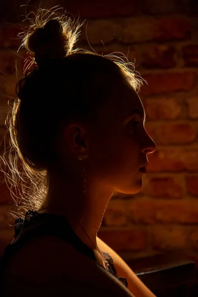 Perfil Uma Jovem Luz Fundo Seu Cabelo Brilha Contra Parede — Fotografia de Stock