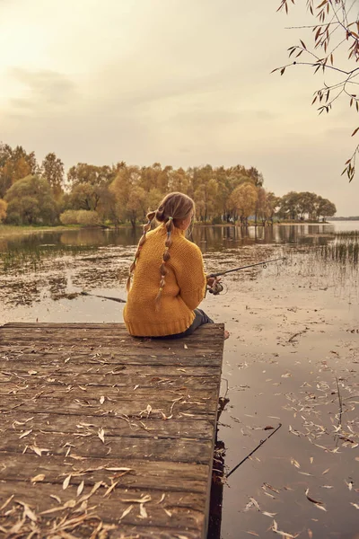 Een Meisje Met Vlechtjes Een Felgele Gebreide Trui Zit Een — Stockfoto