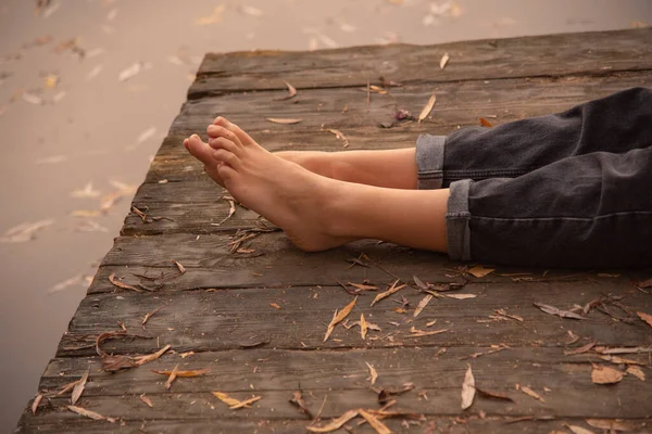 Blote Voeten Voor Vrouwen Het Houten Dek Bezaaid Met Herfstbladeren — Stockfoto