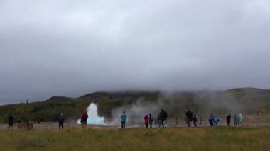 İzlanda Gayzer Strokkur. İnsanlar gayzer Strokkur 'un patlamasını izliyor..