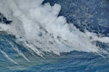 Volkanik lav okyanus dalgalarına akar.