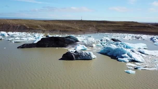 アイスランド。地球温暖化。ラグーンに浮かぶ氷河の氷山の空中ビューのトップダウン. — ストック動画